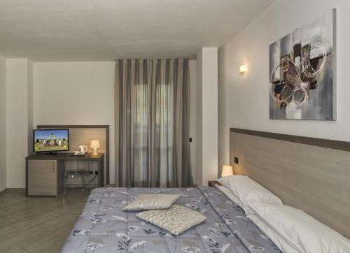 a bedroom with a bed and a television in it at Hotel Lido Inn in Lido di Camaiore