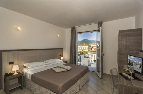 a bedroom with a bed and a large window at Hotel Lido Inn in Lido di Camaiore