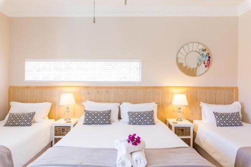 two beds in a room with two lamps at Atlantic Beach Villa in Cape Town
