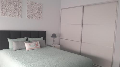 a white bedroom with a bed with a pink pillow at AL - BOA NOVA in Madalena