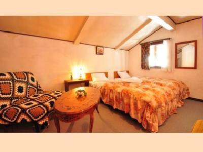 a bedroom with two beds and a table and a chair at Villa Monrepos in Myoko