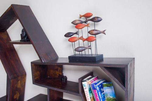 a wooden shelf with mushrooms on it with books at The Miracle Guesthouse & Diving in Koh Tao