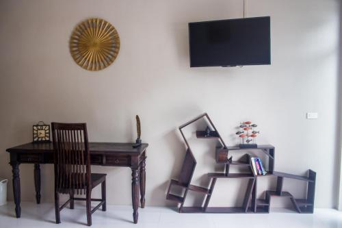 a room with a desk and a table and a chair at The Miracle Guesthouse & Diving in Koh Tao