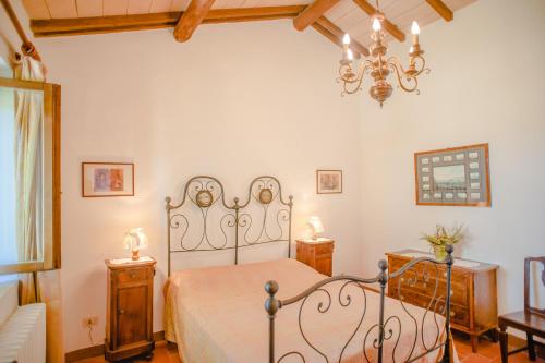 a bedroom with a bed and a chandelier at Agriturismo Collosodo in Monticchiello