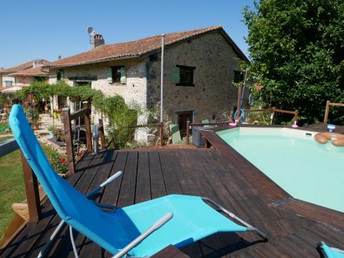 une terrasse avec une chaise bleue et une piscine dans l'établissement chez daisy, à Montbron