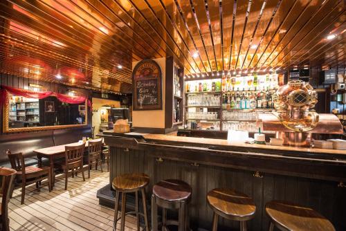 eine Bar mit Holzhockern in einem Restaurant in der Unterkunft Hotel Rheinland Bonn - Bad Godesberg in Bonn