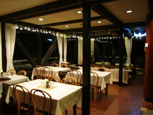 a restaurant with white tables and chairs and lights at Villa Monrepos in Myoko
