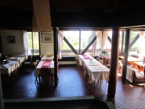 a dining room with tables and chairs and windows at Villa Monrepos in Myoko