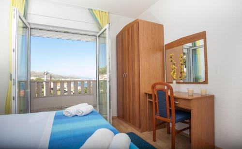 a bedroom with a bed and a desk and a mirror at Apartments Barbara in Trogir