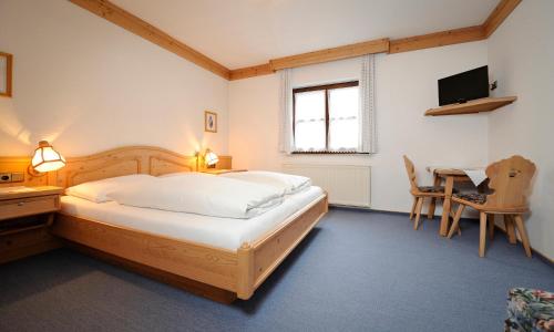 a bedroom with a bed and a desk and a television at Kalßwirt in Bad Aussee