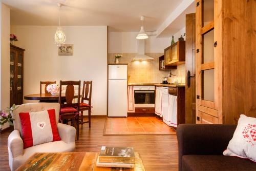 cocina y sala de estar con sofá y mesa en Loft Casa Paloma, en Ansó