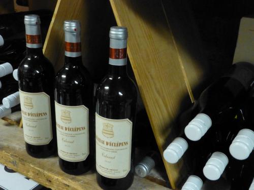 a group of three bottles of wine on a shelf at Hôtel de France in Sainte-Croix
