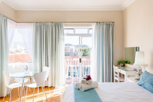 1 dormitorio con 1 cama y 1 mesa con sillas en Atlantic Beach Villa en Ciudad del Cabo