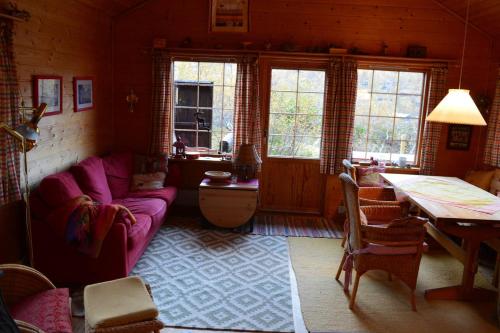 a living room with a purple couch and a table at Haukeli Mountain Cabin in Vågsli
