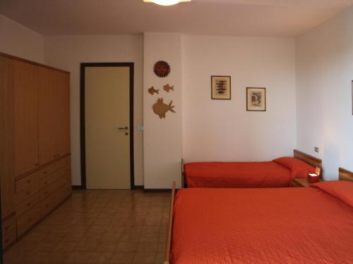 una camera con due letti e una porta per una stanza di Giove a Lignano Sabbiadoro