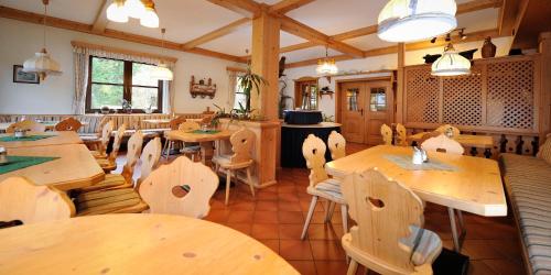 ein Restaurant mit Holztischen und -stühlen in einem Zimmer in der Unterkunft Kalßwirt in Bad Aussee