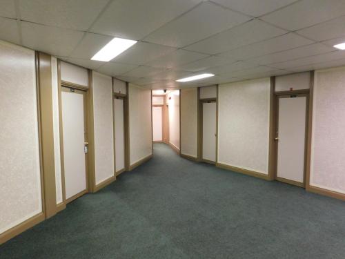 an empty hallway of an office building with doors at Filmores Hotel in Toronto