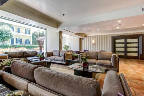 a large living room with couches and tables at Appia Park Hotel in Rome