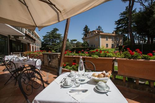 a white table with a bowl of food on a patio at Appia Park Hotel in Rome