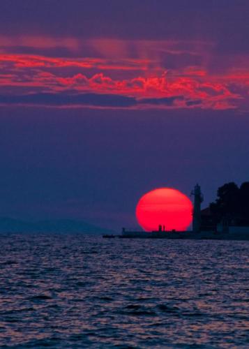 a red sun in the middle of the ocean at Apartment Zora in Zadar