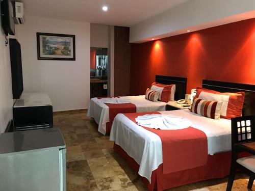 a hotel room with two beds and a television at Hotel Empresarial in Paraíso