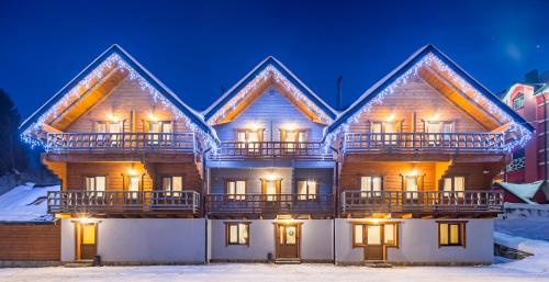 a house in the snow at night at Family Hotel Kaskad in Bukovel