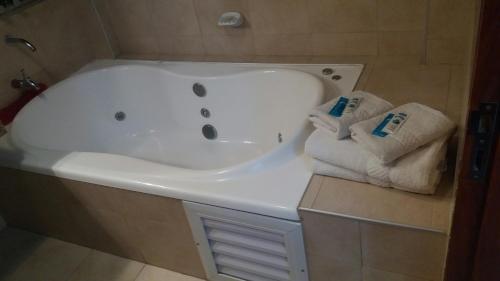 y baño con bañera blanca y toallas. en City Hotel Termal en Termas de Río Hondo