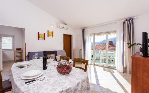 a dining room with a table and a room with a window at Apartments Luka in Baška