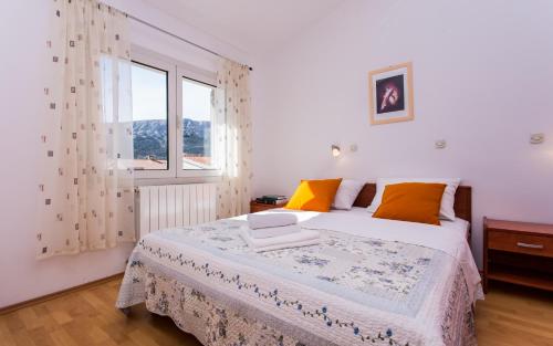 a bedroom with a large bed and a window at Apartments Luka in Baška