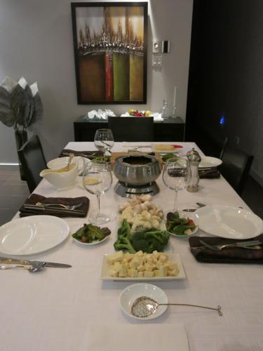 a table with plates of food and wine glasses at Les Chalets Baie Cascouia in Lac Kénogami