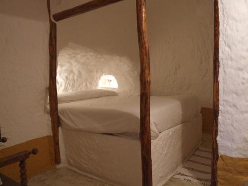 a bedroom with a four poster bed with a window at Al Jatib in Baza