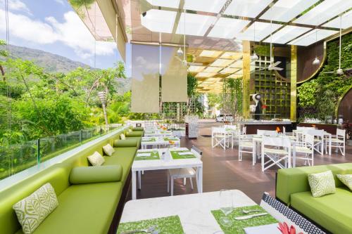 a restaurant with green couches and tables at Hotel Mousai - Adults Only in Puerto Vallarta