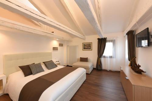 ヴェネツィアにあるスイート アパートメント フラーリの大型ベッドとテレビが備わるホテルルームです。