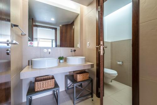 ein Badezimmer mit zwei Waschbecken und einem WC in der Unterkunft Herdade dos Salgados in Guia