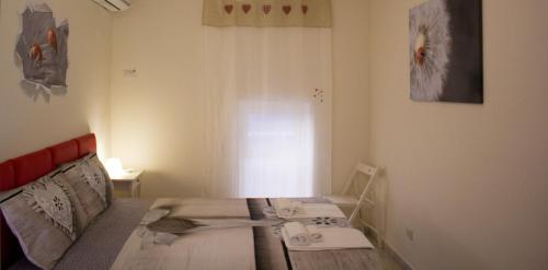 カターニアにあるcasa coccinellaのテーブル付きのベッドが備わる小さな客室です。