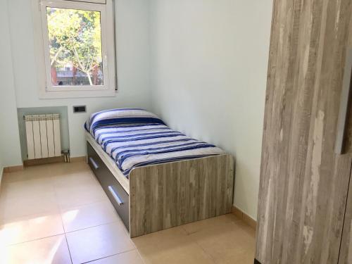 ジローナにあるPISO CÉNTRICO DE 100 M2のベッドと窓が備わる小さな客室です。