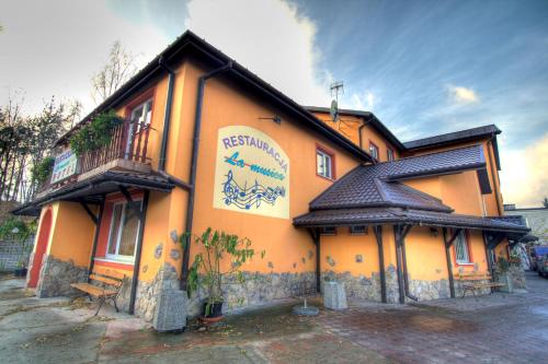 a building with a sign on the side of it at Hotel La-Musica in Piaseczno