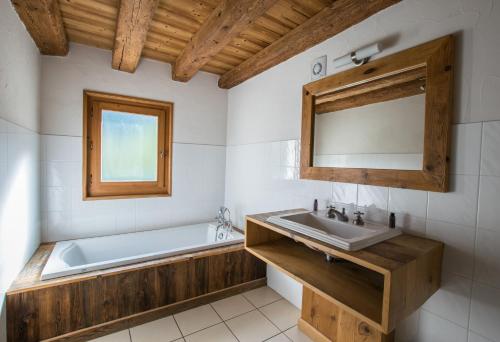 a bathroom with a sink and a bath tub at La Ferme du Château in La Chapelle-dʼAbondance