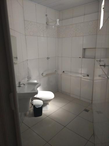 a bathroom with a toilet and a sink at Arahra Hotel in Aparecida de Goiania