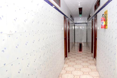 a hallway with white walls and a tile floor at SIU Mansion in Chennai