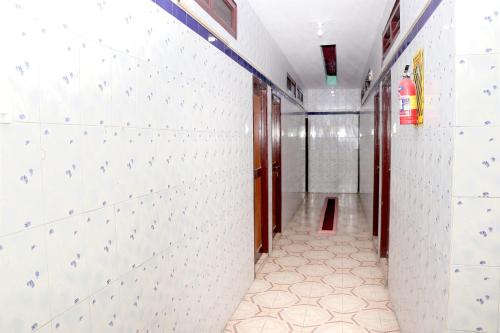 a hallway with white walls and a tile floor at SIU Mansion in Chennai