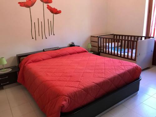 a bedroom with a bed with a red comforter at Stella Del Sud in Cuglieri