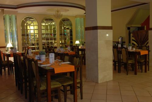 a dining room with tables and chairs in a restaurant at Hotel La-Musica in Piaseczno