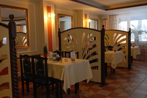 a dining room with a table and chairs in a restaurant at Hotel La-Musica in Piaseczno