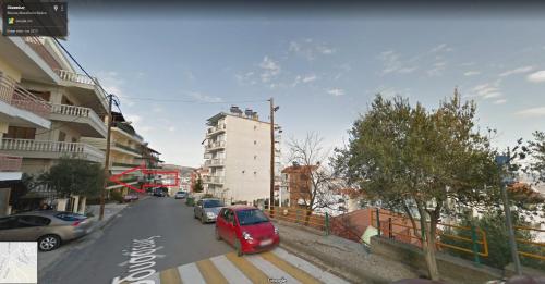 a red car is parked on a city street at Studio Anna Veria in Veria