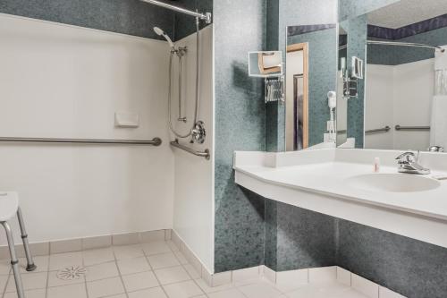 een badkamer met een wastafel en een douche bij Baymont by Wyndham Mequon Milwaukee Area in Mequon