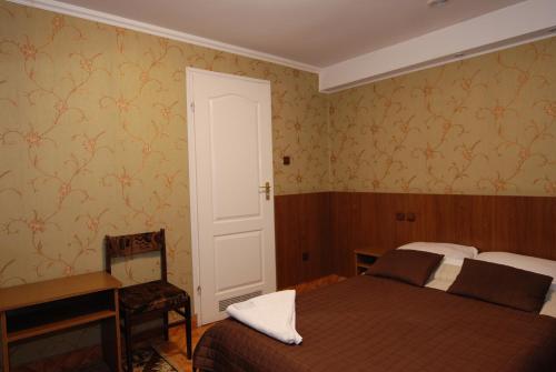 a bedroom with a bed and a desk and a door at Hotel La-Musica in Piaseczno