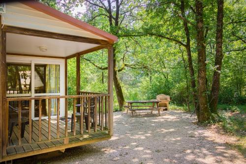 eine Hütte mit einem Picknicktisch und einer Bank in der Unterkunft Domaine De Miraval in Belleserre