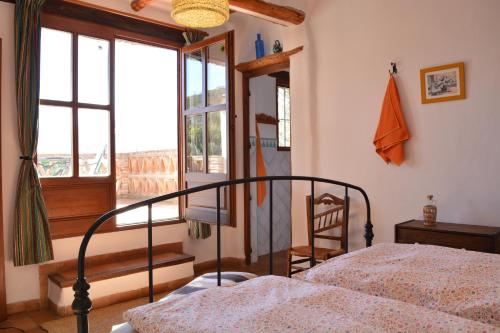 a bedroom with a bed and a window at Casa Rural Cortijo El Potro in Órgiva