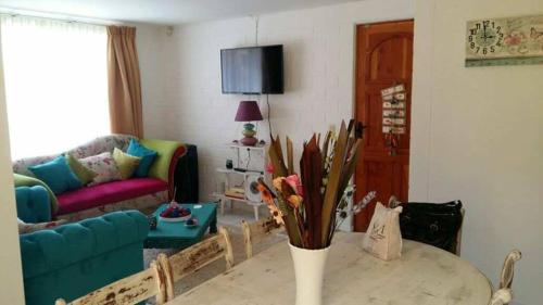 a living room with a couch and a table with flowers at Santa Margarita Coquimbo in Coquimbo